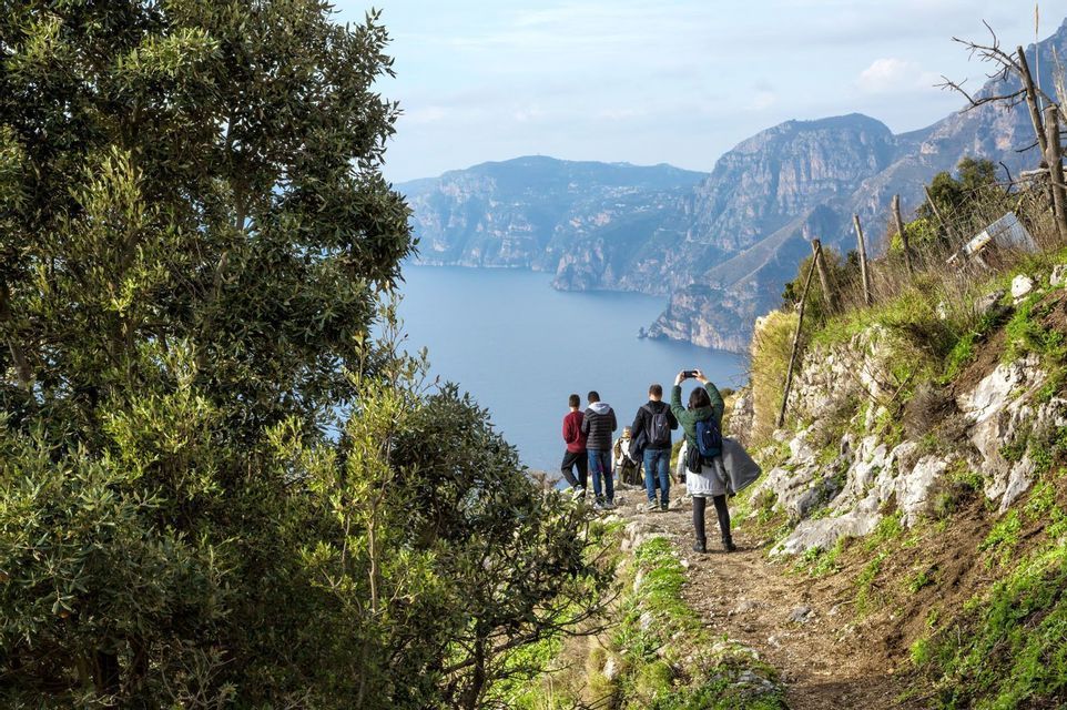 Personas paseando por un acantilado en la Costa Amalfitana