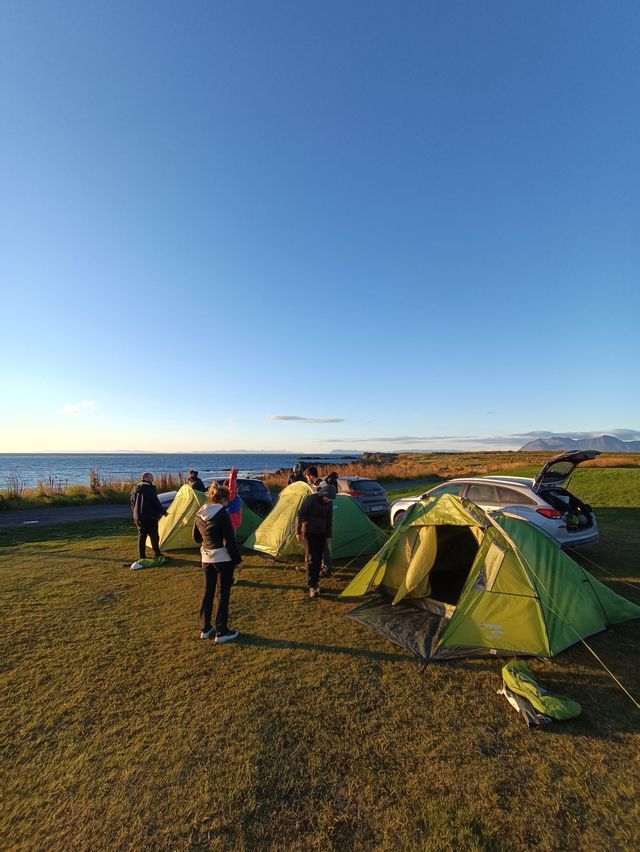 Photo de tentes campant dans une prairie islandaise surplombant la mer en été - WeRoad