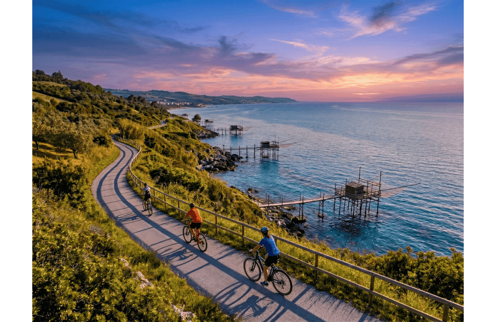 Veduta aerea di un gruppo WeRoad in bicicletta su un sentiero costiero verde, con capanne di pescatori sull'acqua al tramonto.