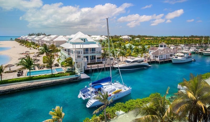 Sailboats moored in a turquoise harbor in the Bahamas