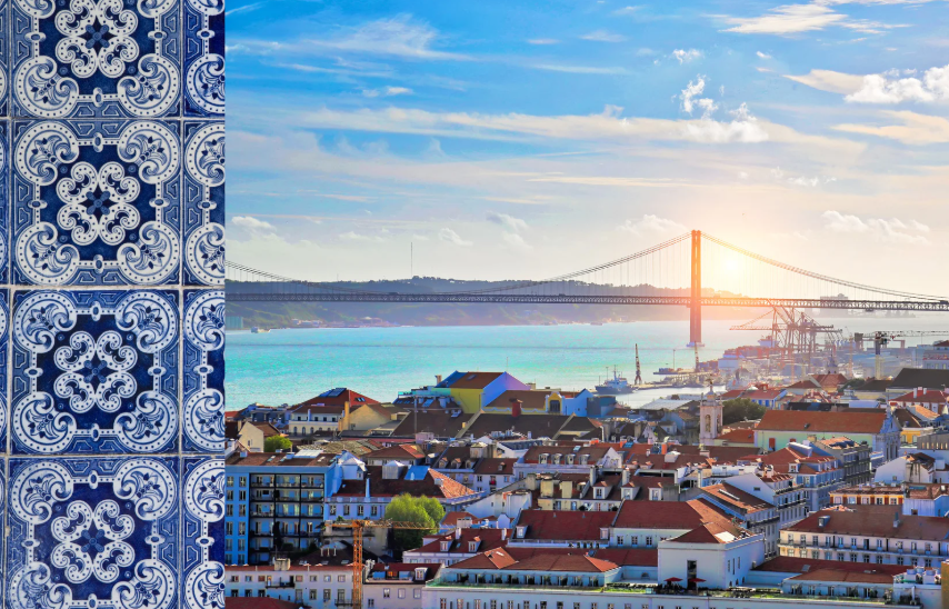 Una colonna di piastrelle a motivi blu e bianchi sulla sinistra incornicia una vista della città con un ponte sospeso sull'acqua al tramonto.
