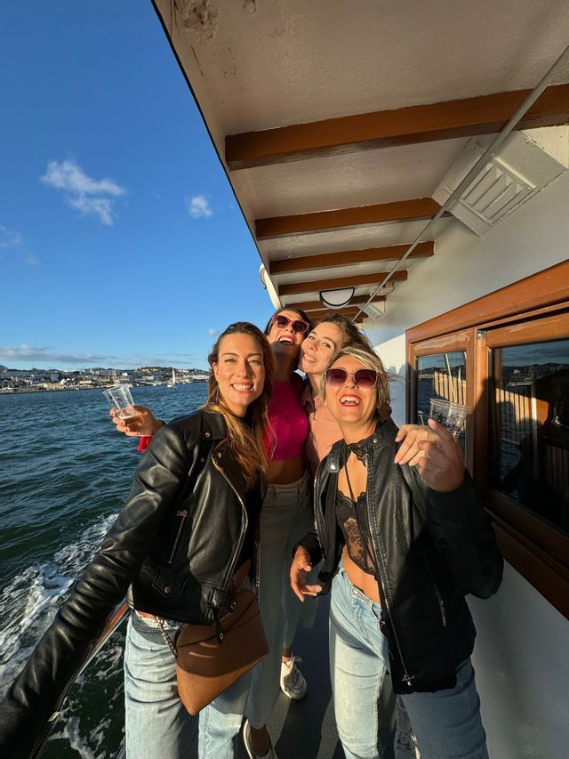 Un viaggio di gruppo WeRoad di quattro donne che sorridono e posano per una foto sul ponte di una barca in mare.
