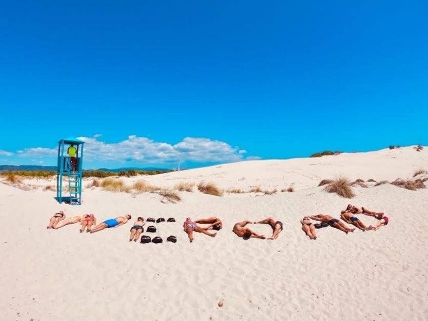 A WeRoad group trip lying on a white sand beach, using their bodies and bags to spell out the word WEROAD under a blue sky.