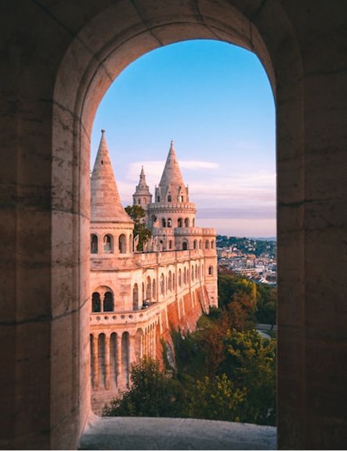 The white turrets of the Fisherman's Bastion above Budapest at sunset.