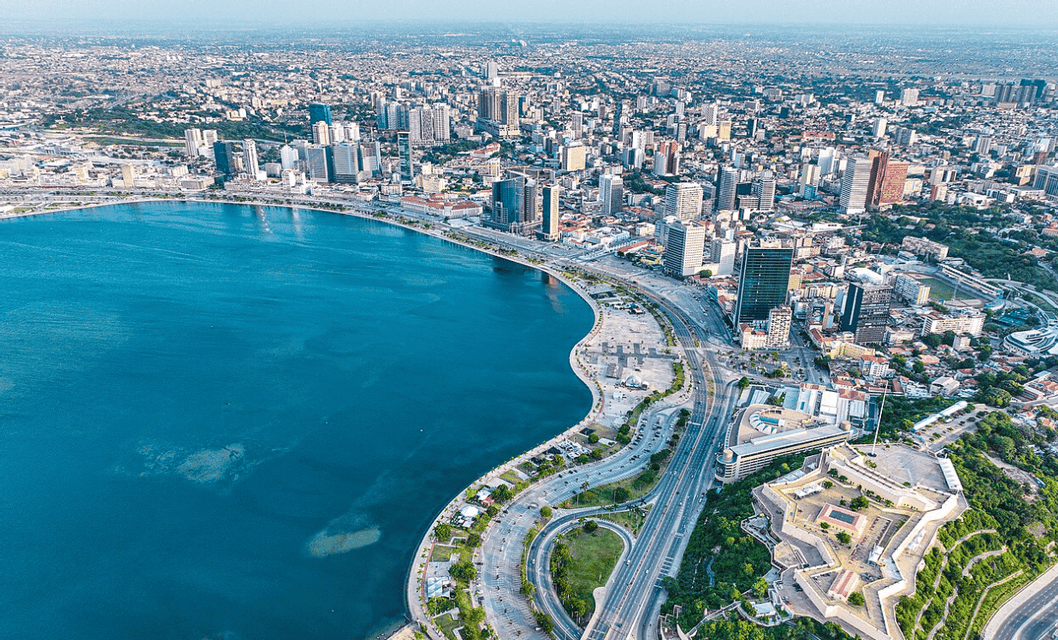 Una vista aerea di una densa città costiera con una baia curva e una storica fortezza a forma di stella che domina il lungomare.