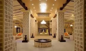 The interior of a spacious hall with large square pillars and walls constructed from blocks of salt, illuminated by ceiling lights.