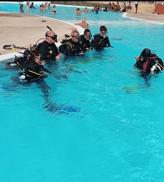 Un viaggio di gruppo WeRoad impara ad immergersi con un istruttore in piscina.