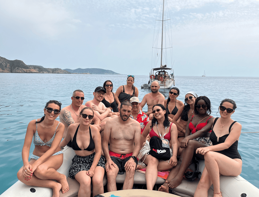 Un groupe WeRoad en maillot de bain posant sur un bateau en mer.