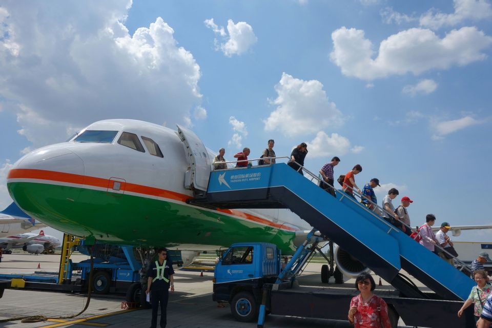 Un viaggio di gruppo WeRoad con persone che sbarcano da un aereo sulla pista tramite una scala mobile.