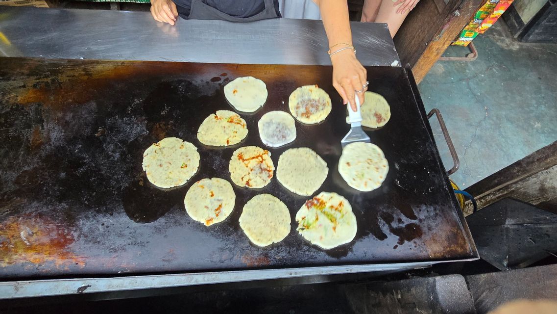 Pupusas cooking on a hot comal, the national dish of El Salvador