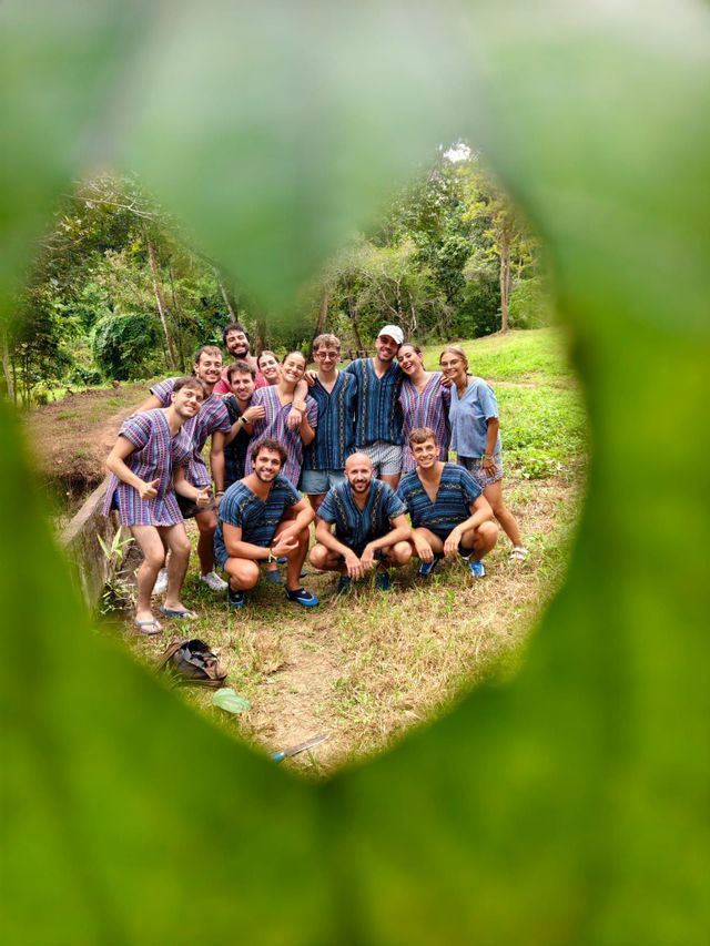 Un viaggio di gruppo WeRoad con tuniche stampate abbinate, in posa all'aperto incorniciati da un foro a forma di cuore in una foglia.