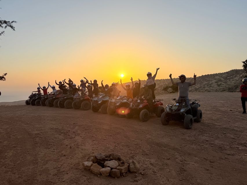 Un viaggio di gruppo WeRoad di viaggiatori in posa sui quad con le braccia alzate al tramonto su un altopiano sterrato arido
