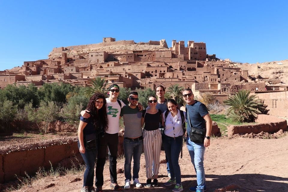 Foto de grupo ante una ciudad sobre el desierto en Marruecos