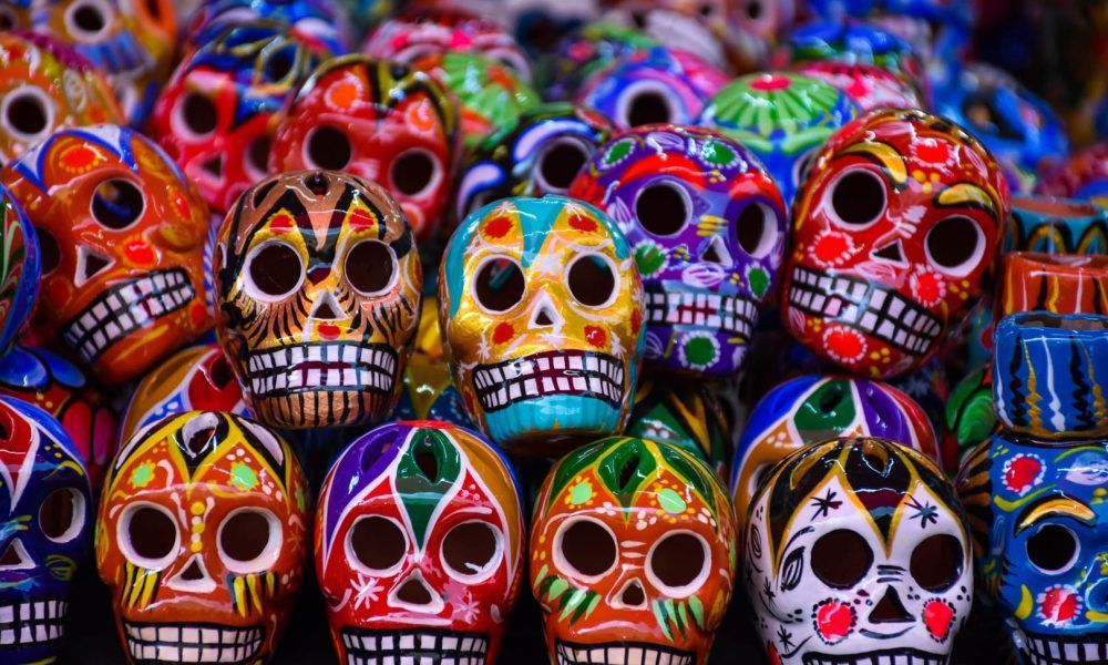 Un primo piano di coloratissimi teschi in ceramica, conosciuti anche come Calaveras, finemente decorati e raggruppati.