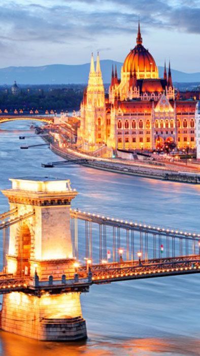 The Chain Bridge and the Hungarian Parliament lit up along the Danube at dusk.