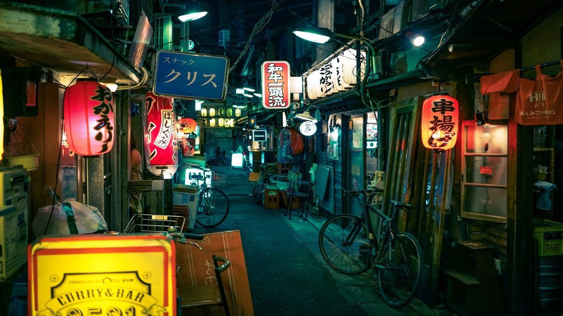 Un vicolo stretto giapponese di notte, illuminato da lanterne di carta rosse luminose, insegne al neon e lampioni.