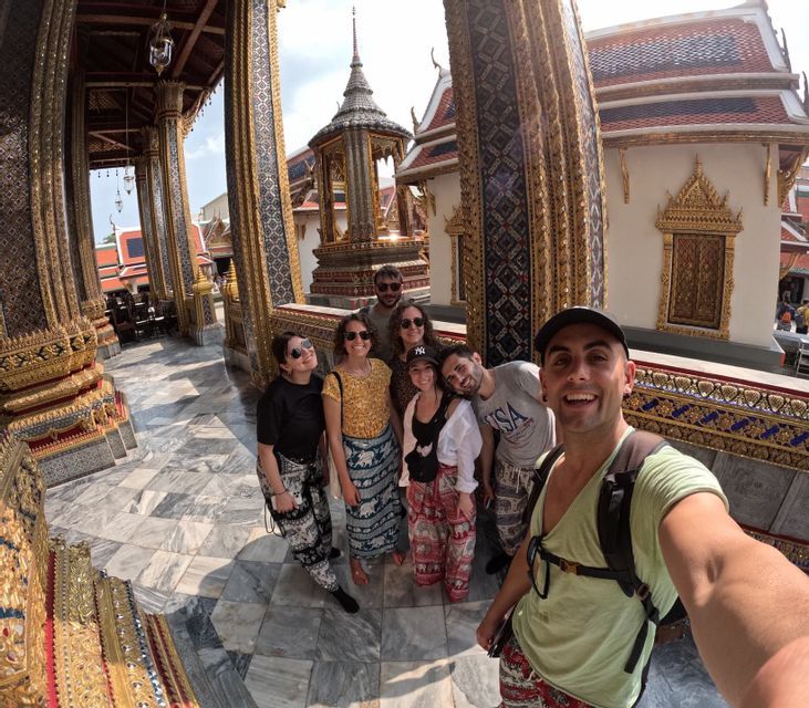 A WeRoad group trip takes a selfie inside an ornate temple with golden pillars and a marble floor.