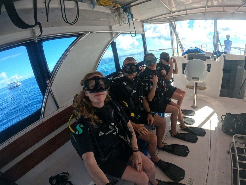 Un viaggio di gruppo WeRoad in equipaggiamento subacqueo completo seduti all'interno di una barca, preparandosi per un'immersione in mare.
