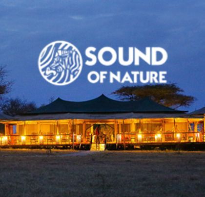 Un lodge safari con luci calde si illumina al tramonto, con il logo 'Sound of Nature' che risplende nel cielo.