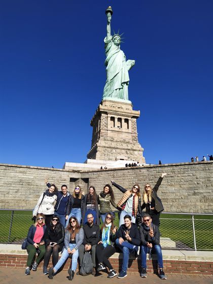 Foto di gruppo sotto la Statua della Libertà, in New York in autunno - WeRoad