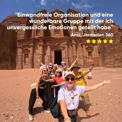Eine WeRoad-Gruppe macht ein Selfie vor einem großen, in einen Felsen gehauenen historischen Denkmal.