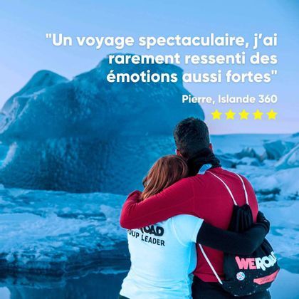 Un guide WeRoad et un autre voyageur s'étreignent devant un immense iceberg bleu.
