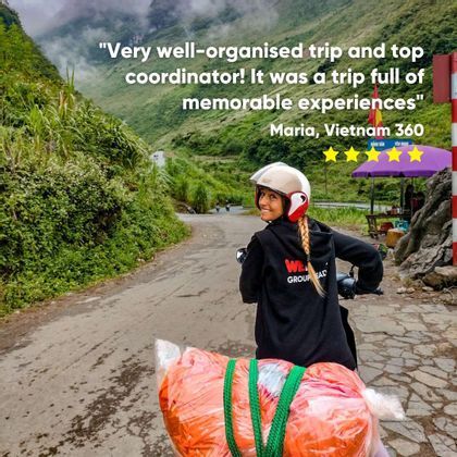 A woman on a WeRoad trip smiles while riding a scooter on a winding road through lush, green mountains.