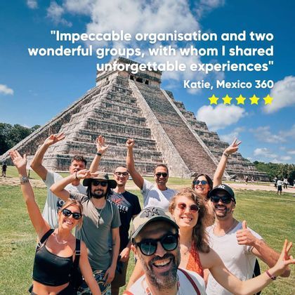 A WeRoad group trip smiling and posing for a selfie in front of a large stone pyramid on a sunny day.