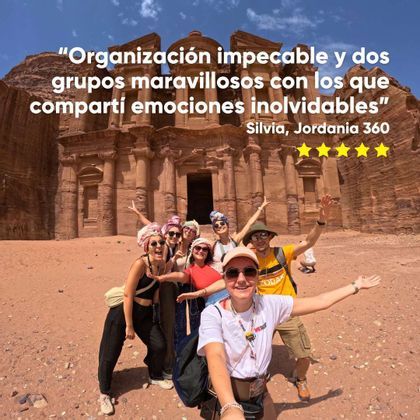 Un grupo de WeRoad posa para una selfie frente a un gran monumento tallado en la roca.