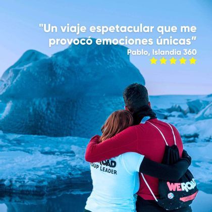 Un líder de grupo de WeRoad y otra persona abrazándose por detrás mientras observan un gran iceberg azul.