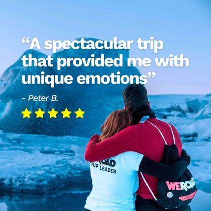 A man and a WeRoad group leader hugging while looking out at a landscape of icebergs and snow.