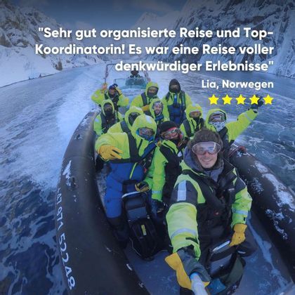 Eine WeRoad-Gruppe in leuchtender Winterausrüstung macht ein Selfie auf einem Festrumpfschlauchboot in einem verschneiten, eisigen Gewässer.