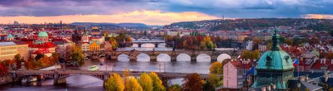 The bridges of Prague over the Vltava river surrounded by autumn colours.