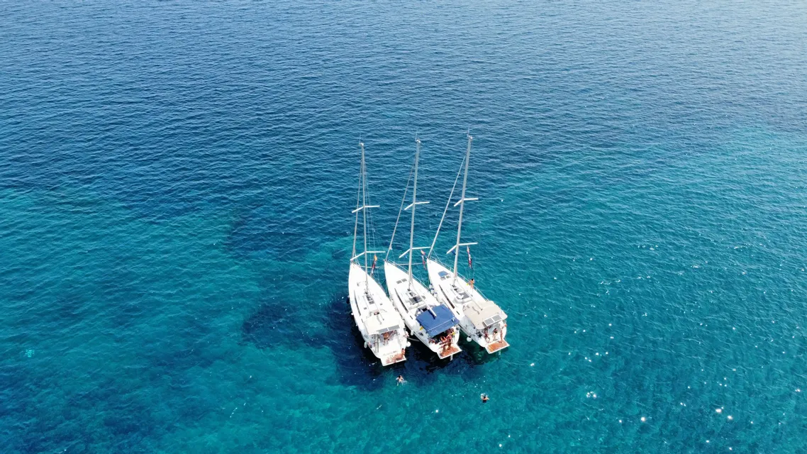 Tre barche a vela ormeggiate in un mare turchese