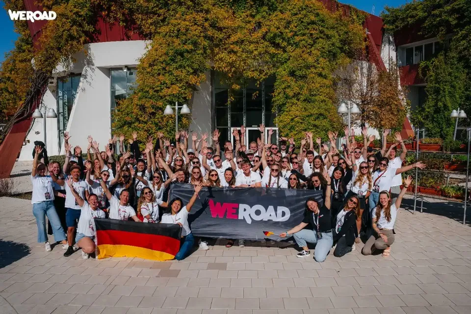 Un grande gruppo di WeRoader con uno striscione WeRoad