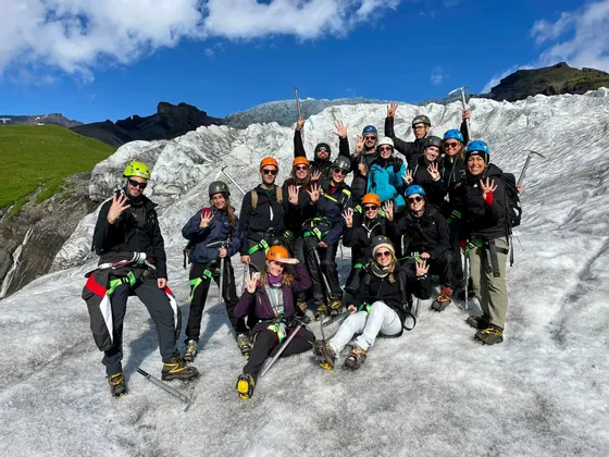 Un gruppo WeRoad in posa su un ghiacciaio, con caschi, imbracature e piccozze.