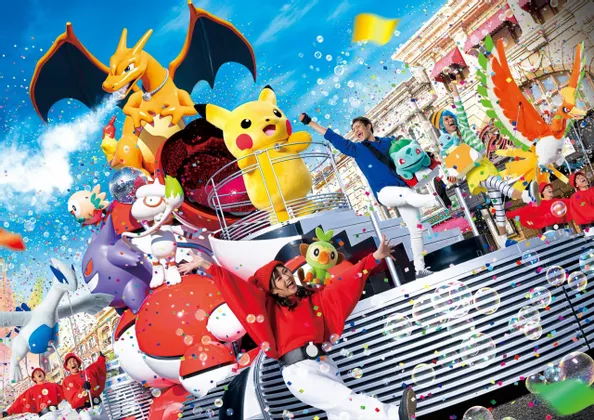 Un carro allegorico vivace con artisti e grandi figure di personaggi Pokémon come Pikachu e Charizard tra coriandoli e bolle.