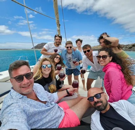 WeRoad Gruppenreise: Anstoßen mit Rotwein auf einem Segelboot an einem sonnigen Tag auf See.