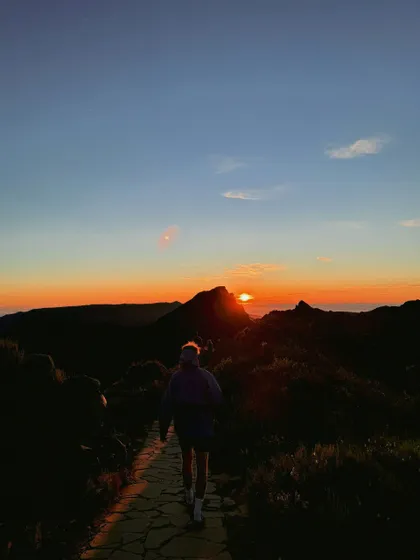 Un viaggio di gruppo WeRoad in montagna, escursione su un sentiero di pietra all'alba.