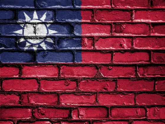 Die Nationalflagge Taiwans, gemalt auf eine strukturierte rote Backsteinmauer.