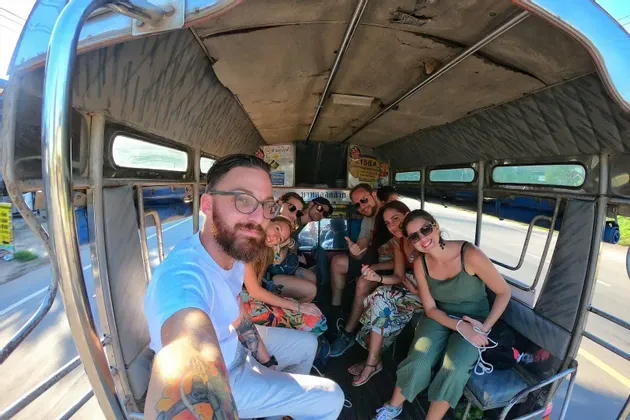 Un viaje en grupo de WeRoad con gente sonriente se toma una selfie dentro de un vehículo de transporte local.